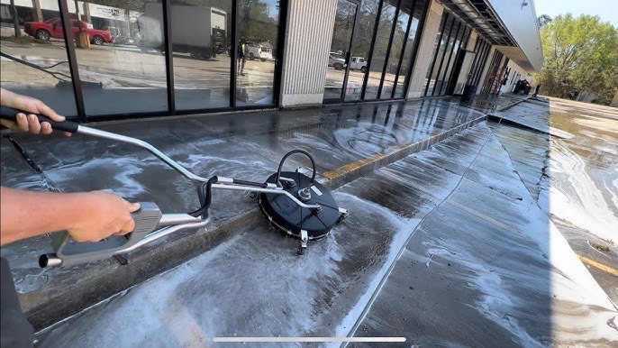 Surface cleaner washing the walkway in front of a commercial storefront